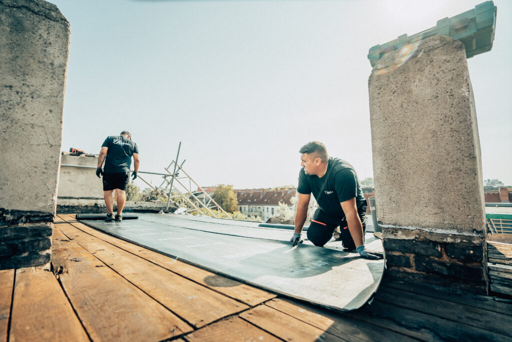Monteure der Dachbau Stefan Höft GmbH bei Abdichtungsarbeiten auf einem Flachdach
