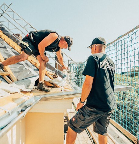 Dachdecker der Dachbau Stefan Höft GmbH am geöffneten Steildach bei der Dachdämmung in Berlin